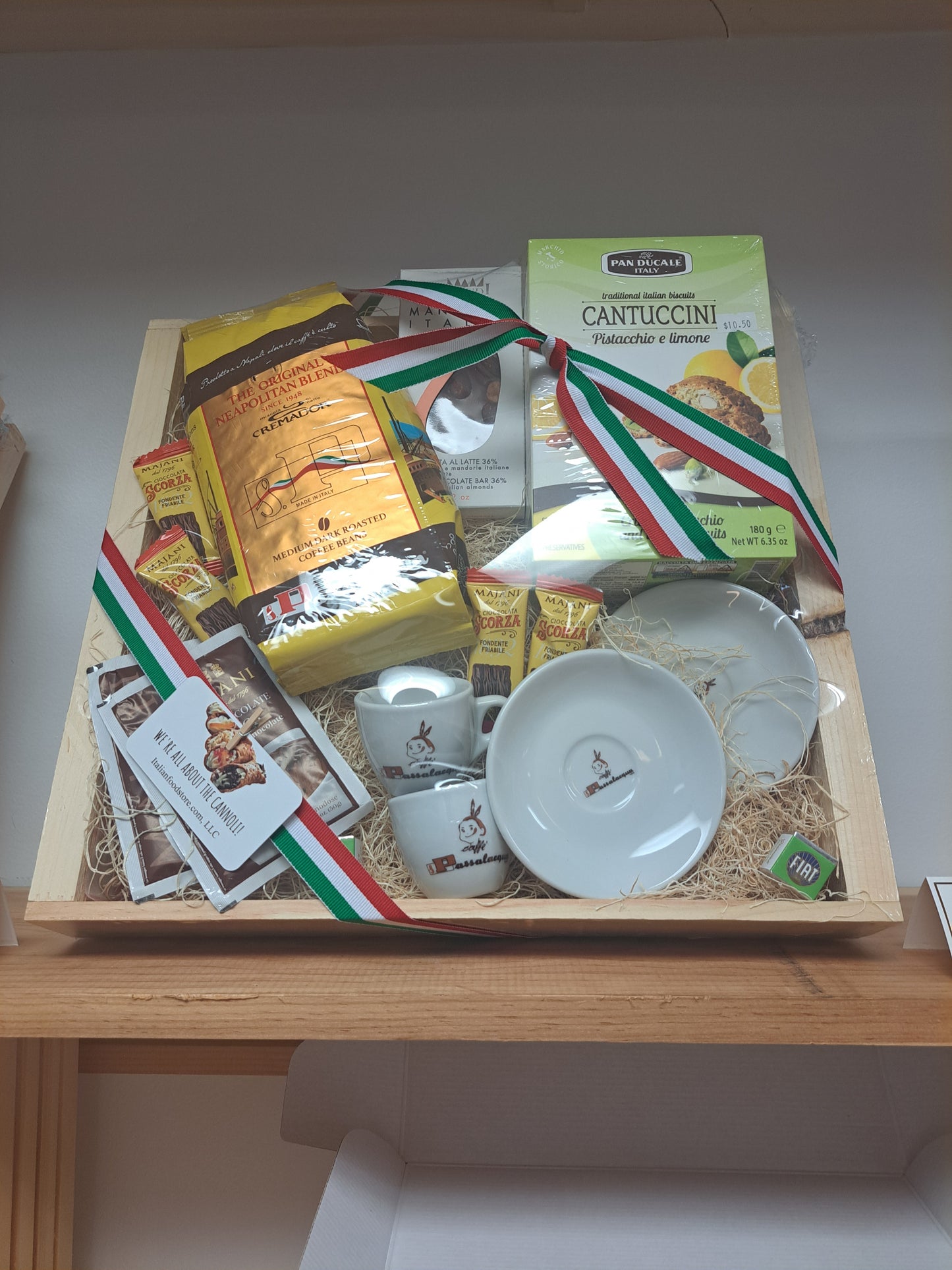 Gift box with Italian-themed products including pasta and a flag on a wooden surface.