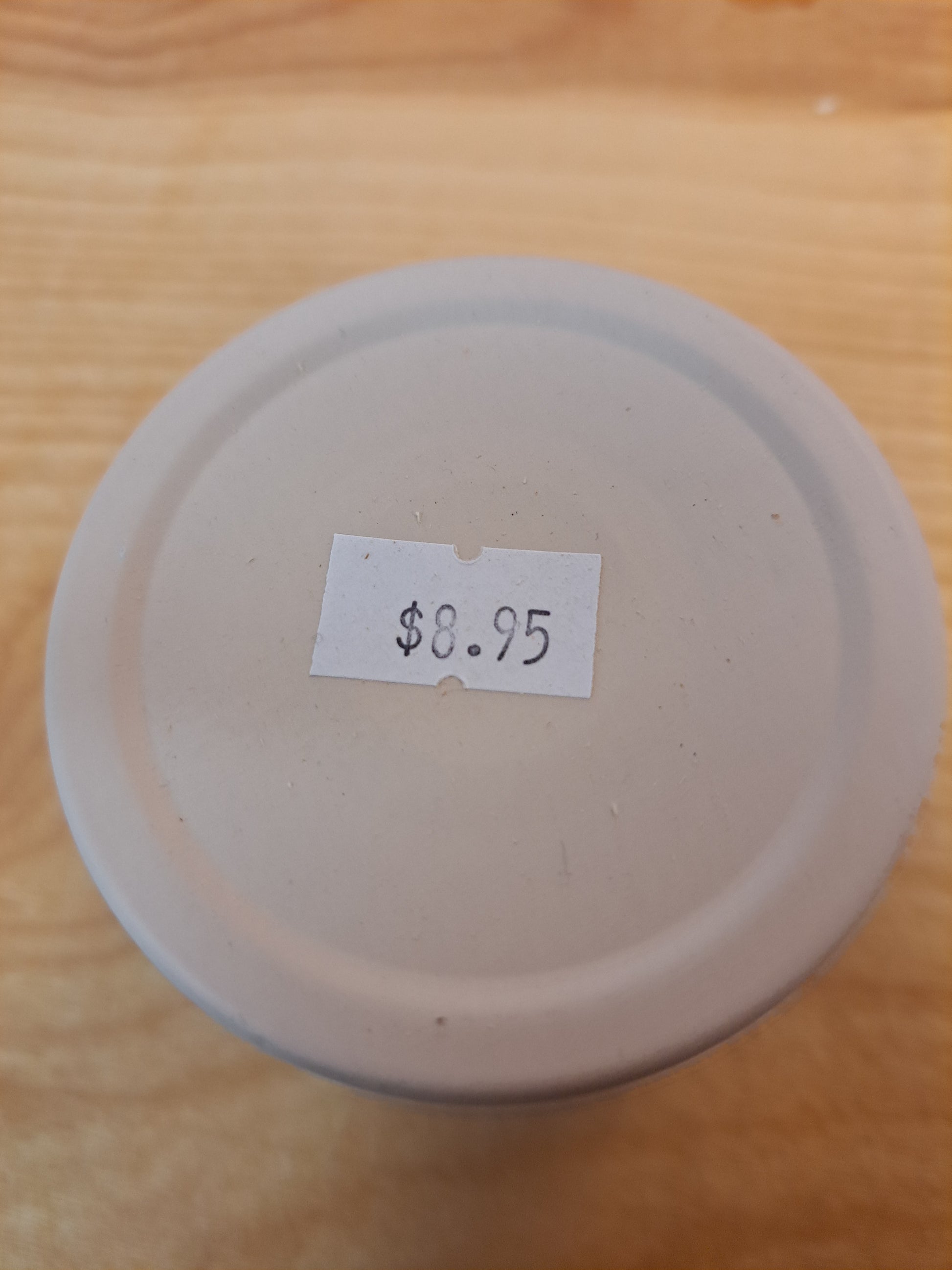 White ceramic plate with a price tag label on a wooden surface