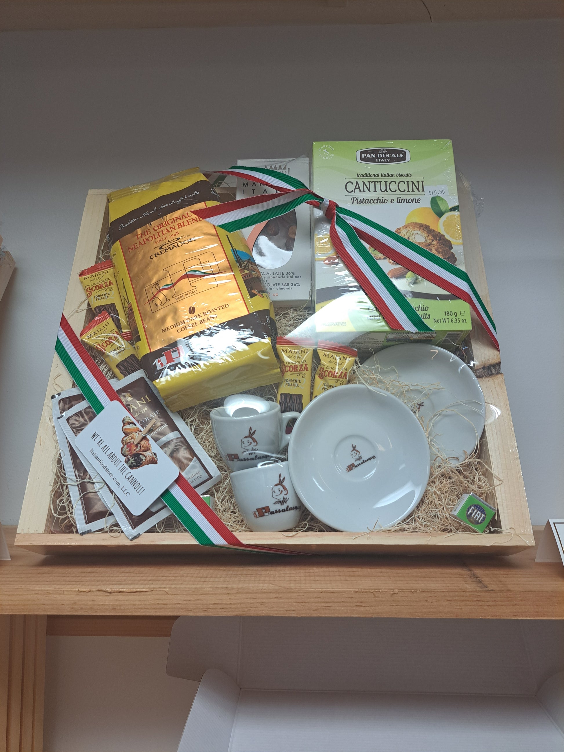 Gift box with Italian-themed products including pasta and a flag on a wooden surface.