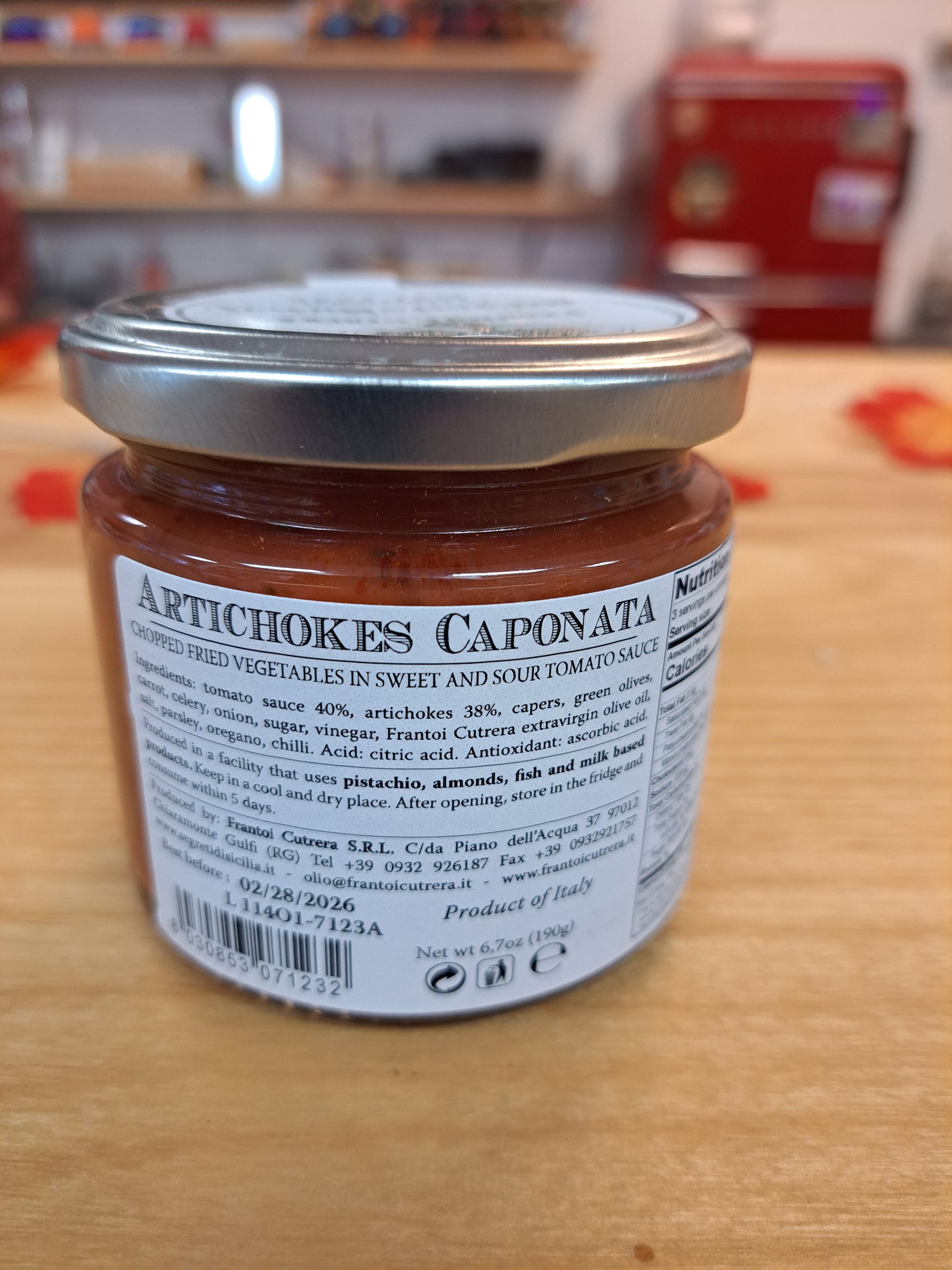 Jar of artichokes caponata on a wooden surface with colorful background