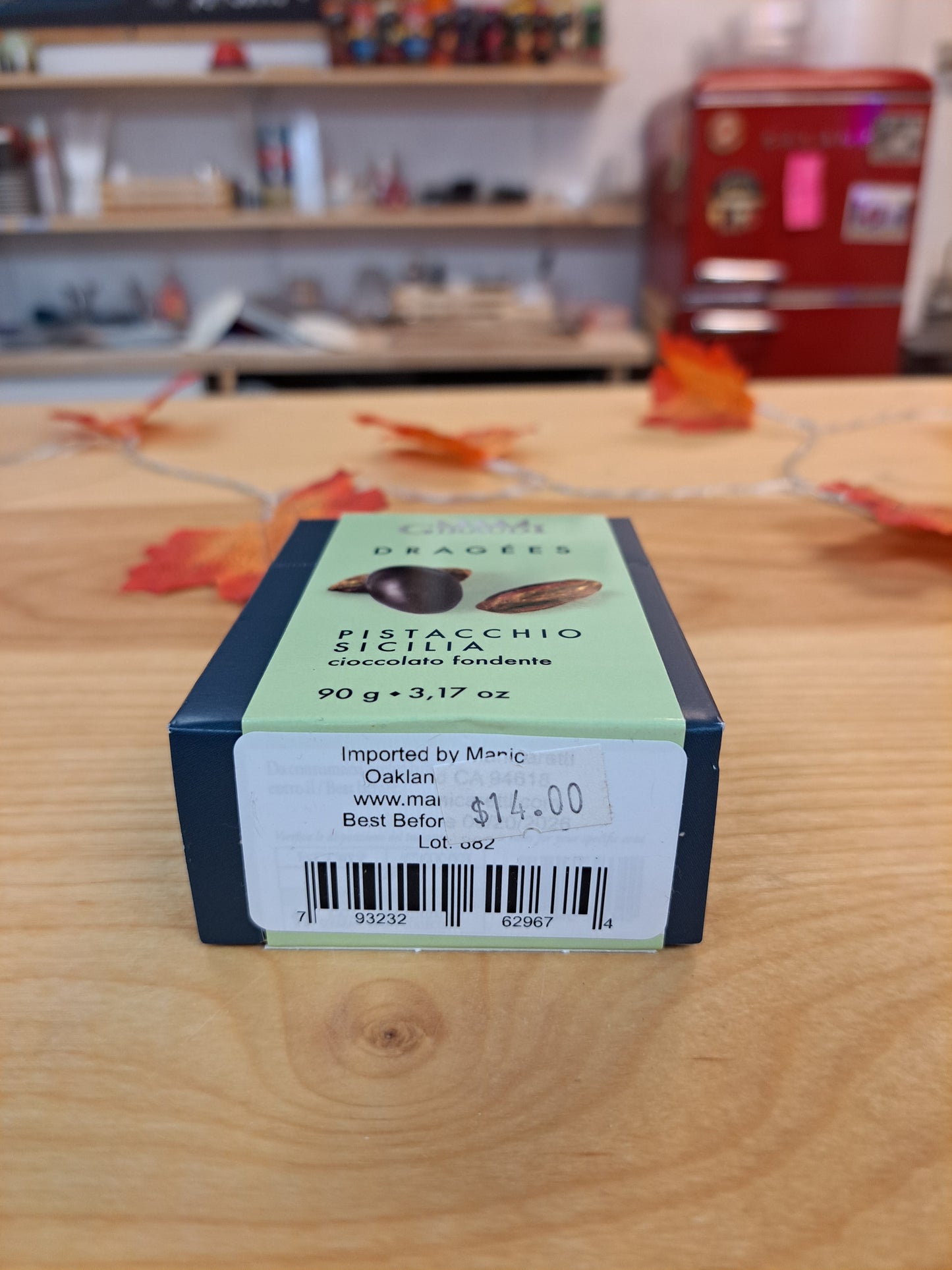 Box of candy with a label on a wooden surface, with a store setting in the background.