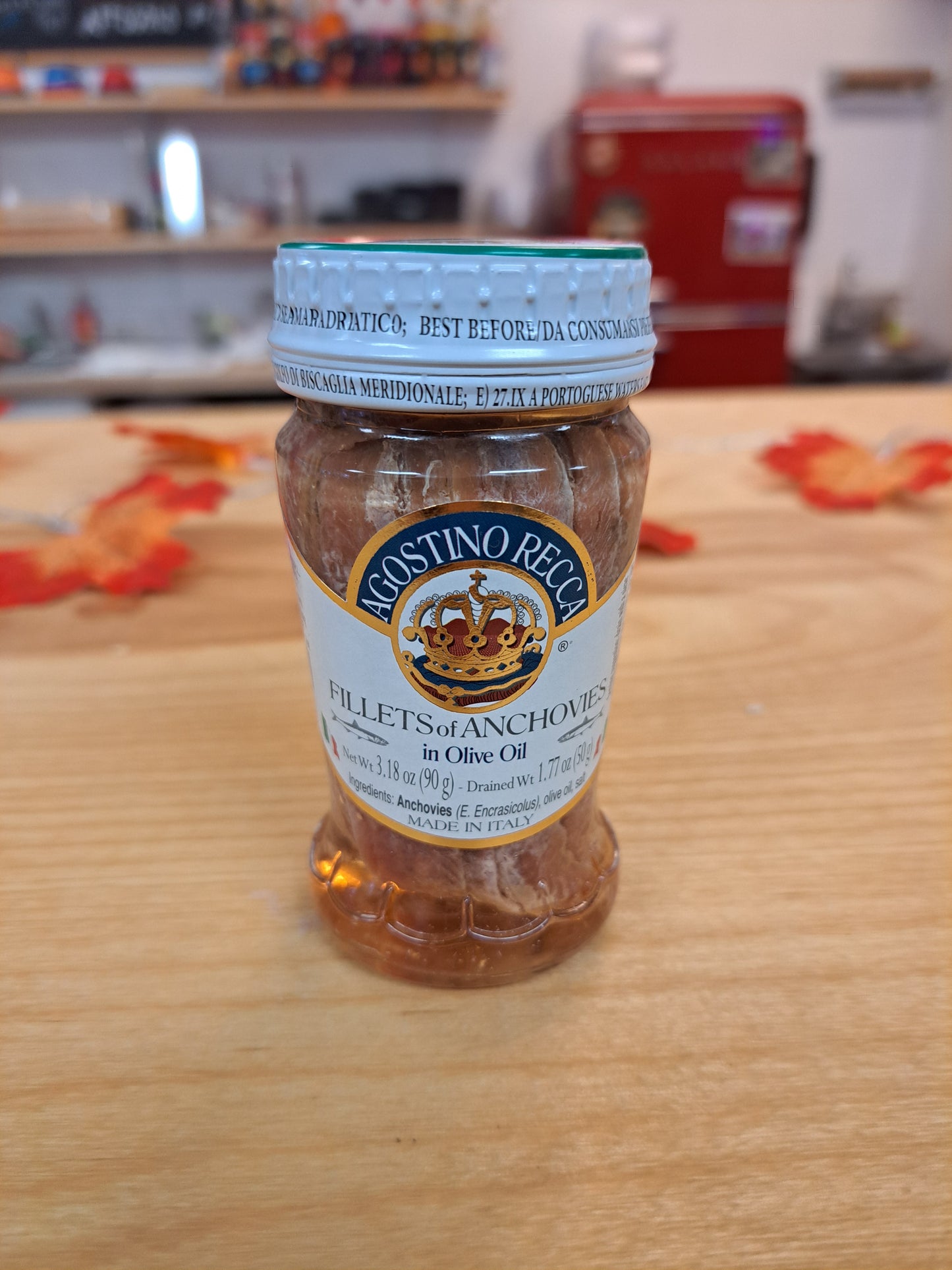 Bottle of Fillets of Anchovies on a wooden surface with a blurred background