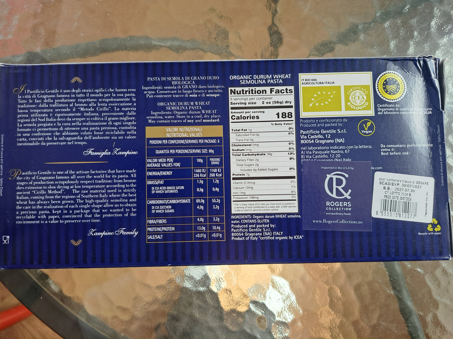 Back of a blue product packaging with text and labels on a camouflage-patterned surface