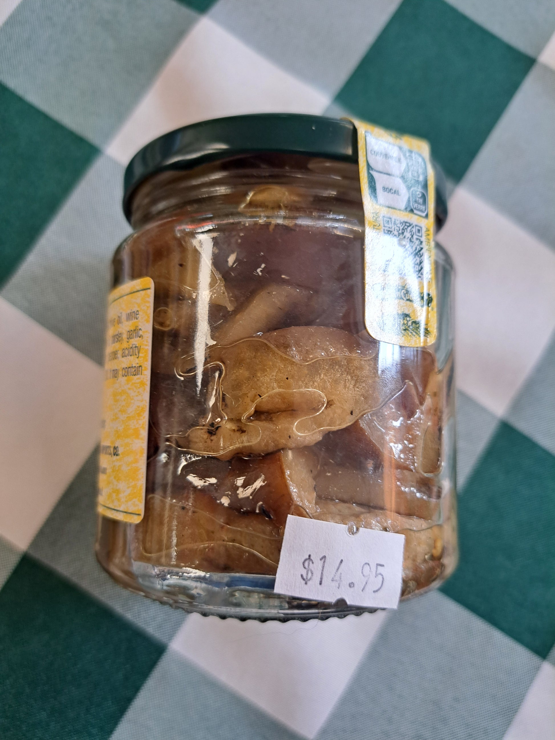 Jar of pickled vegetables with price tag on a checkered tablecloth