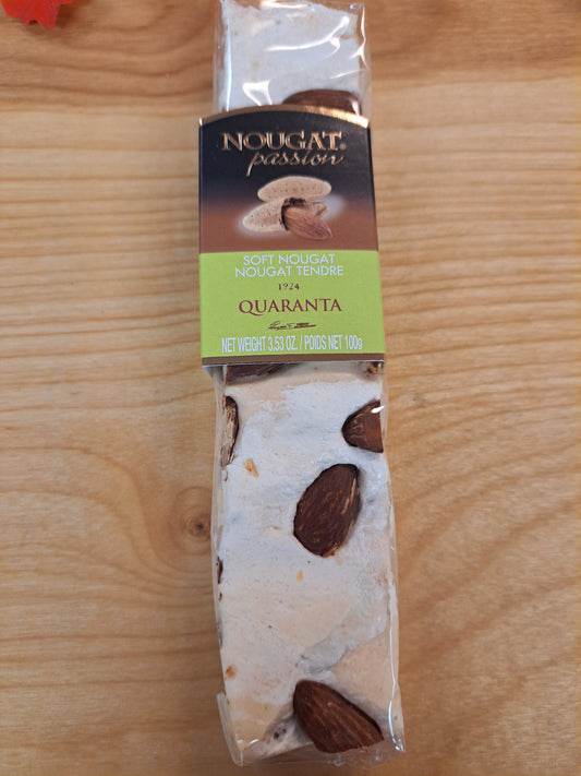 Packaged nougat with visible almonds on a wooden surface